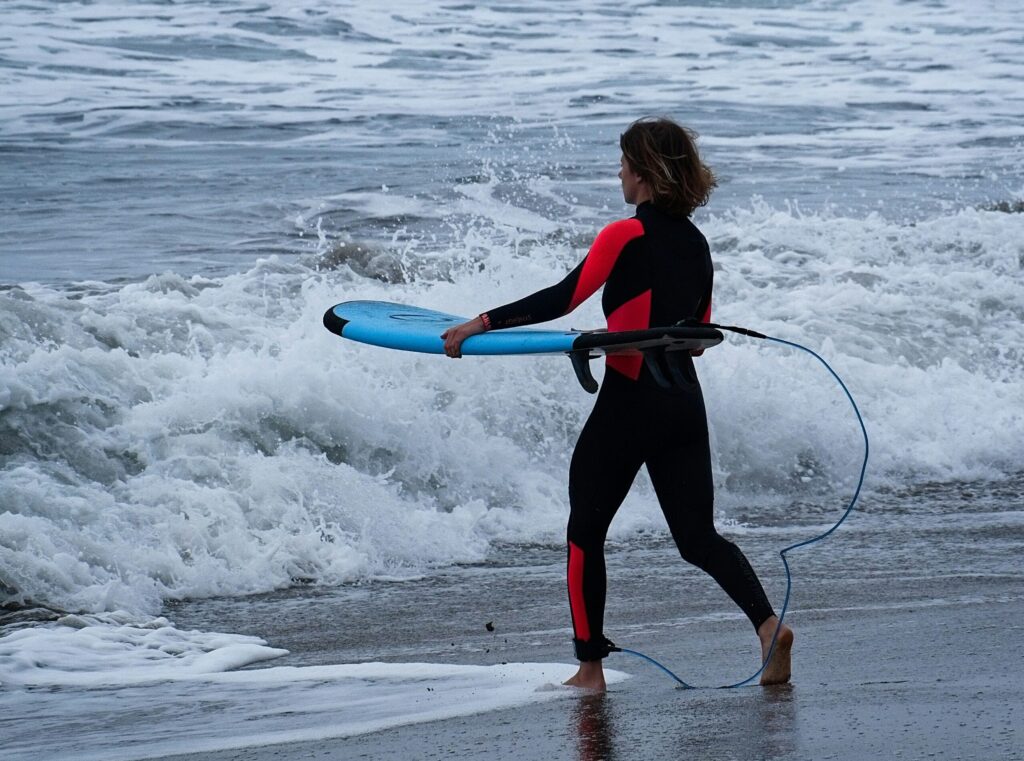 A woman surfer about to enter the water - Women's sport